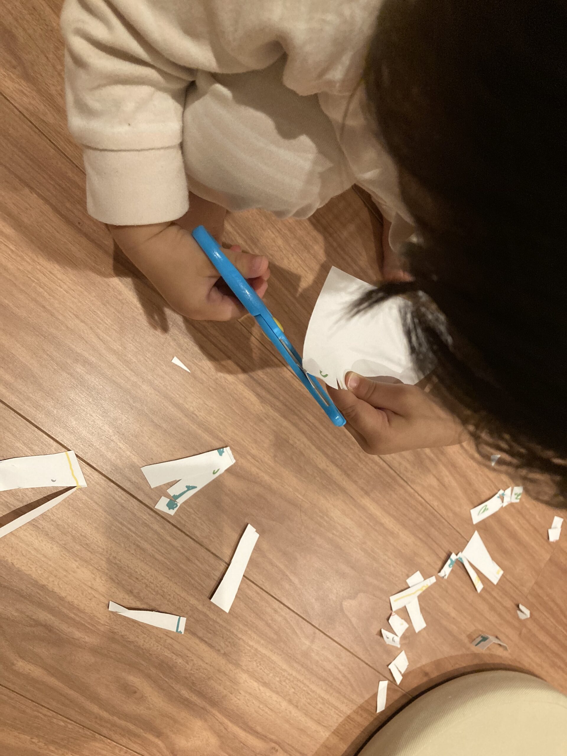 ハサミで紙を切る2歳児