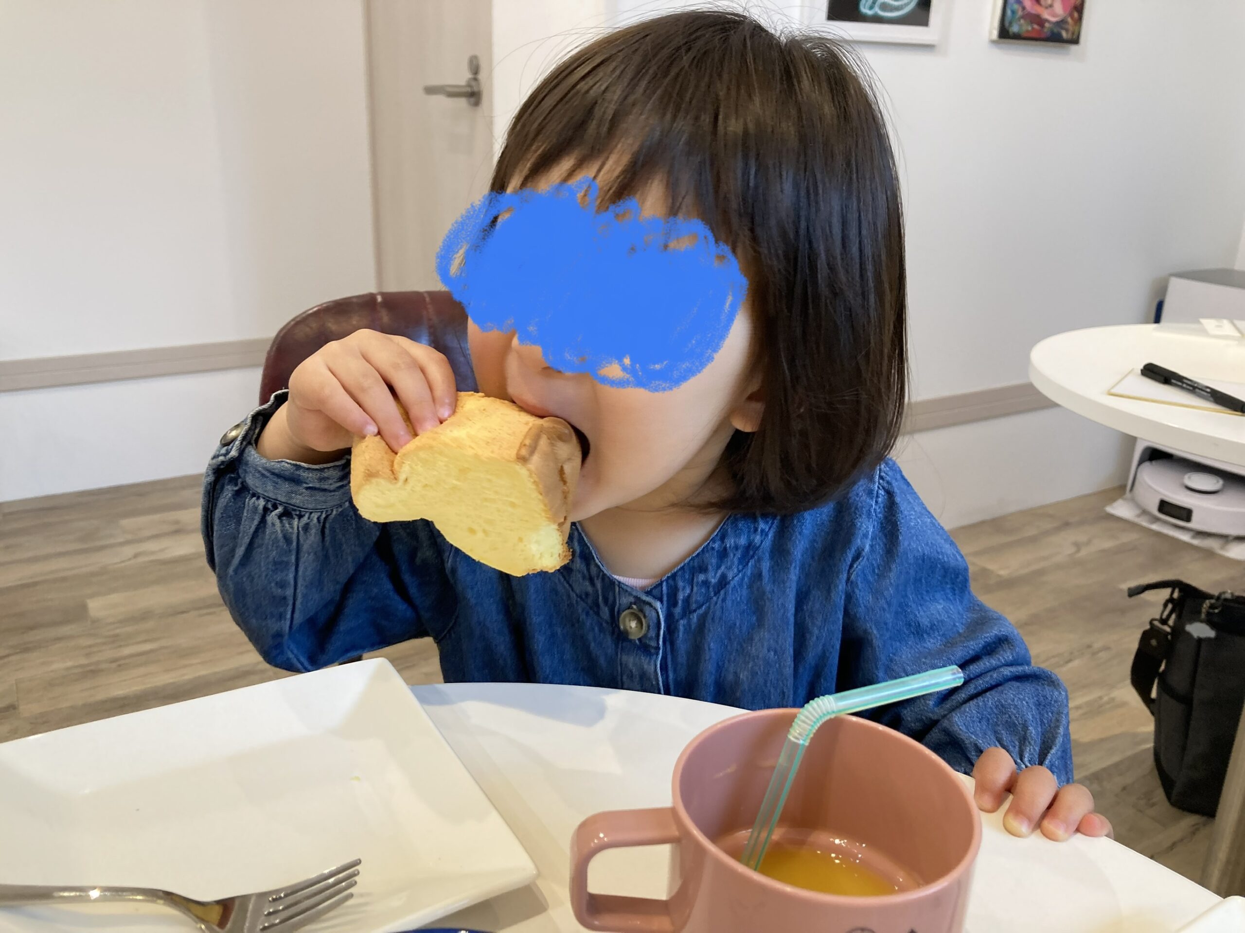 大きな口でシフォンケーキを食べる2歳児